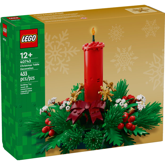 Centro de mesa navideño LEGO con vela roja, bayas, estrellas doradas y hojas verdes